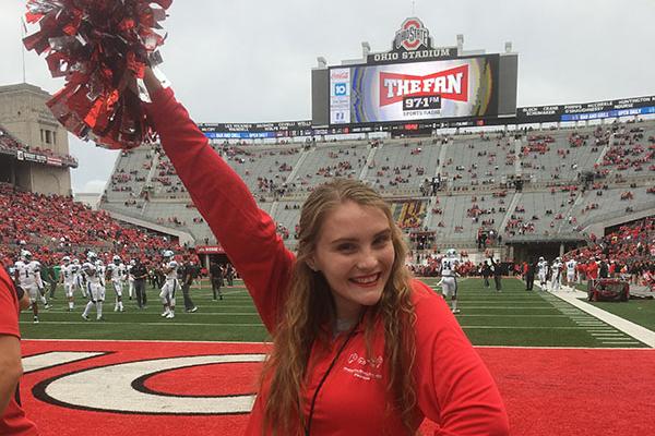 Photograph of Kayleigh standing on the field of the Shoe, OSU football stadium