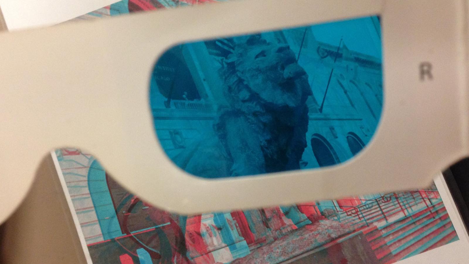 Photograph of 3D glasses and the image of a lion statue popping out 