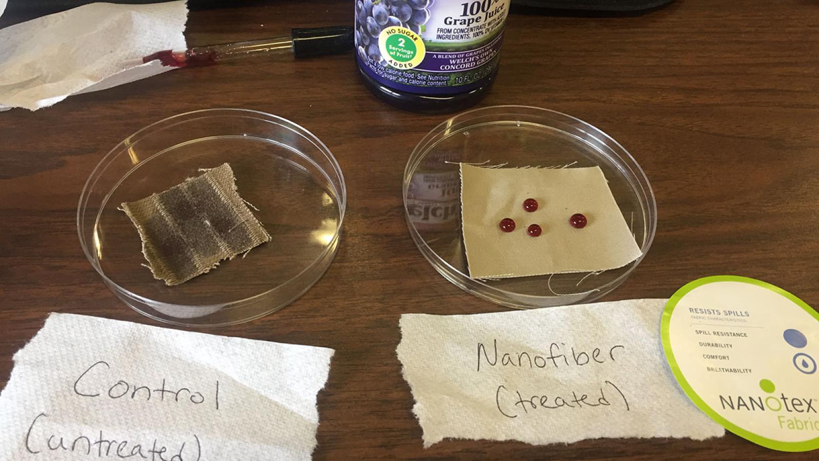 Photograph of a nanochemistry experiment showing untreated fabric vs. nanofiber fabric. The untreated fabric has the grape juice soaking in whereas the nanofiber fabric has droplets of grape juice and it is not sinking in. 