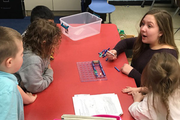 Photograph of volunteer teaching kindergartners about circuits and engineering