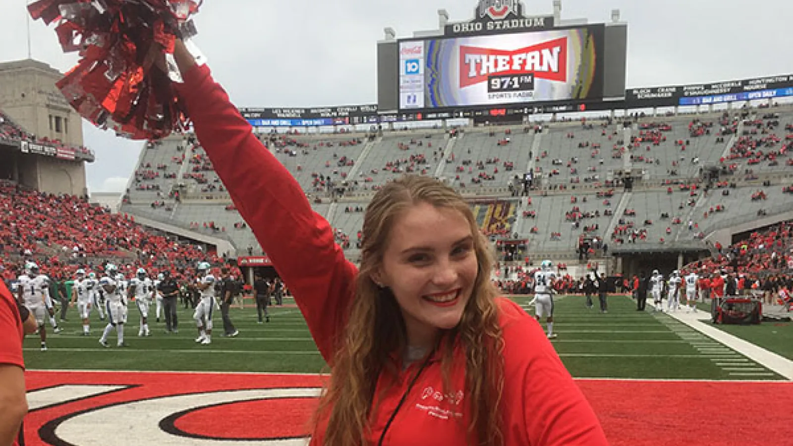 Photograph of Kayleigh standing on the field of the Shoe, OSU football stadium