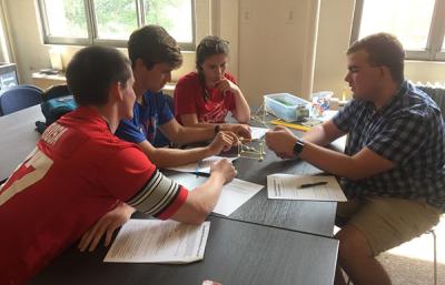 Photograph of Nick working with other WOW volunteer to build a spaghetti-marshmallow tower.