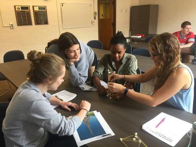 Photograph of WOW volunteers working on building a spaghetti-marshmallow tower during a training session