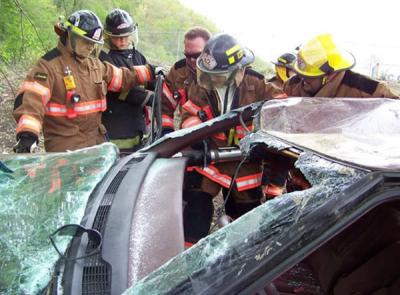 Image of Kayleigh as a volunteer firefighter working on taking apart a car windshield