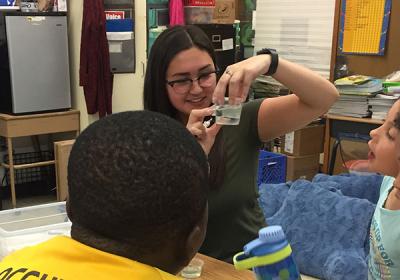 Photograph of Rosemary teaching 2nd graders about turbidity in water samples
