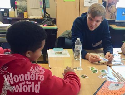 Photo of WOW volunteer working with 5th grader on the all about fruits and vegetables activity