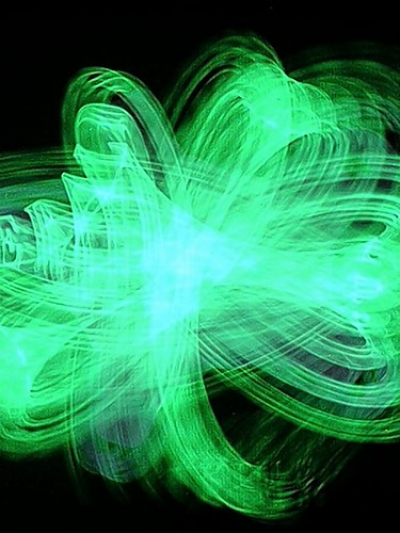 Photography of green light streaked around to form a clover leaf