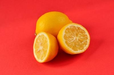 Photograph of two lemons - one cut in half and one whole lemon