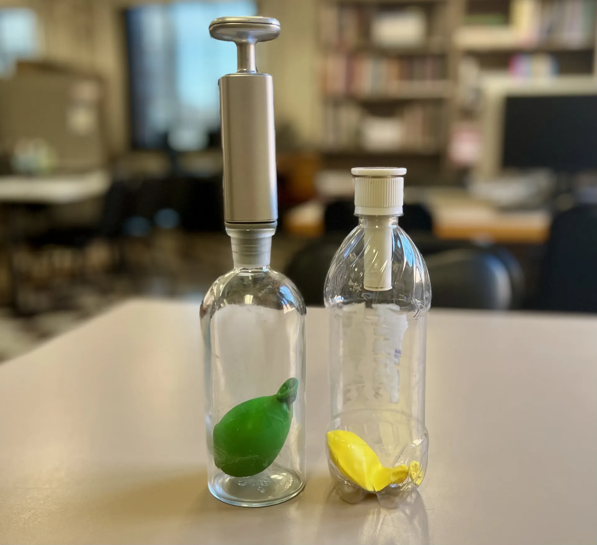 soda bottles attached to pumps with balloons inside the bottles