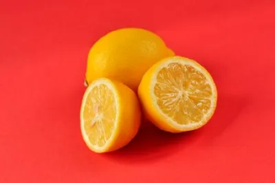 Photograph of two lemons - one cut in half and one whole lemon