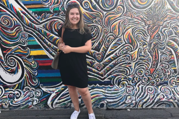 Photo of Allison in Germany in front of wall art.