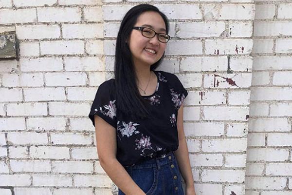 Photograph of Deborah next to a brick wall